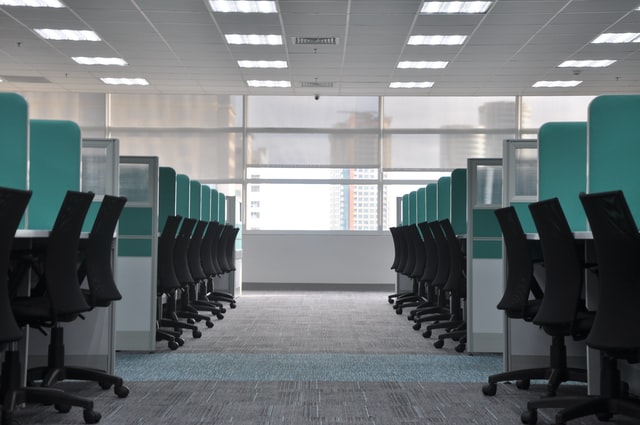Photo of empty office space with desk chairs and cubicles