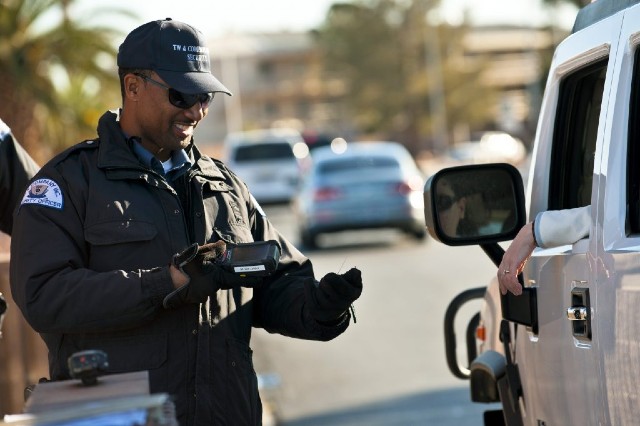 Paris Garrett, TW and Company security officer, scans identification cards using a biometric identification sensor at the Nellis Main Gate, March 20, 2012 at Nellis Air Force Base, Nev. Nellis is introducing a new security program, the Defense Biometric Identification System, to manage personnel, property and installation access. (U.S. Air Force photo by Senior Airman Brett Clashman)
